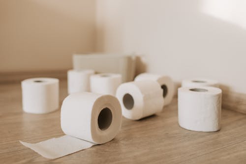 Free White Toilet Paper Roll on Wooden Floor Stock Photo