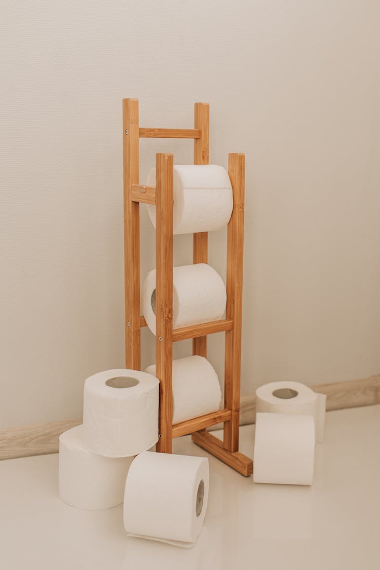 White Toilet Paper Rolls On Wooden Rack