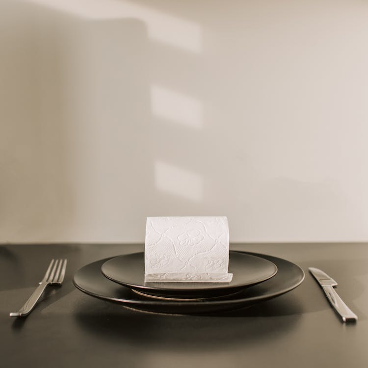 Free Toilet paper roll on dish with fork and knife Stock Photo