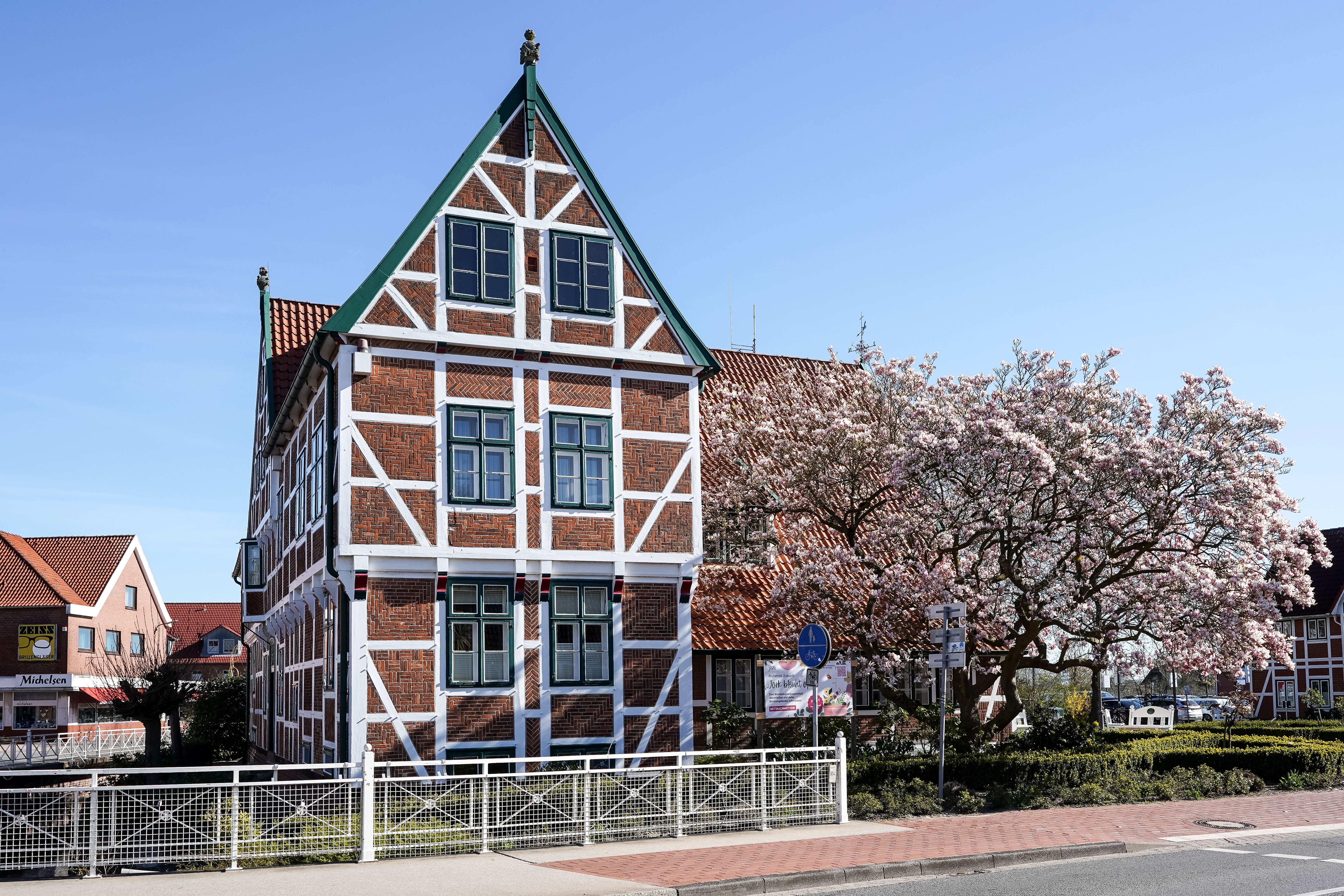 Beautiful timbered house in Jork, Germany, showcasing historic architecture amid spring blossoms.