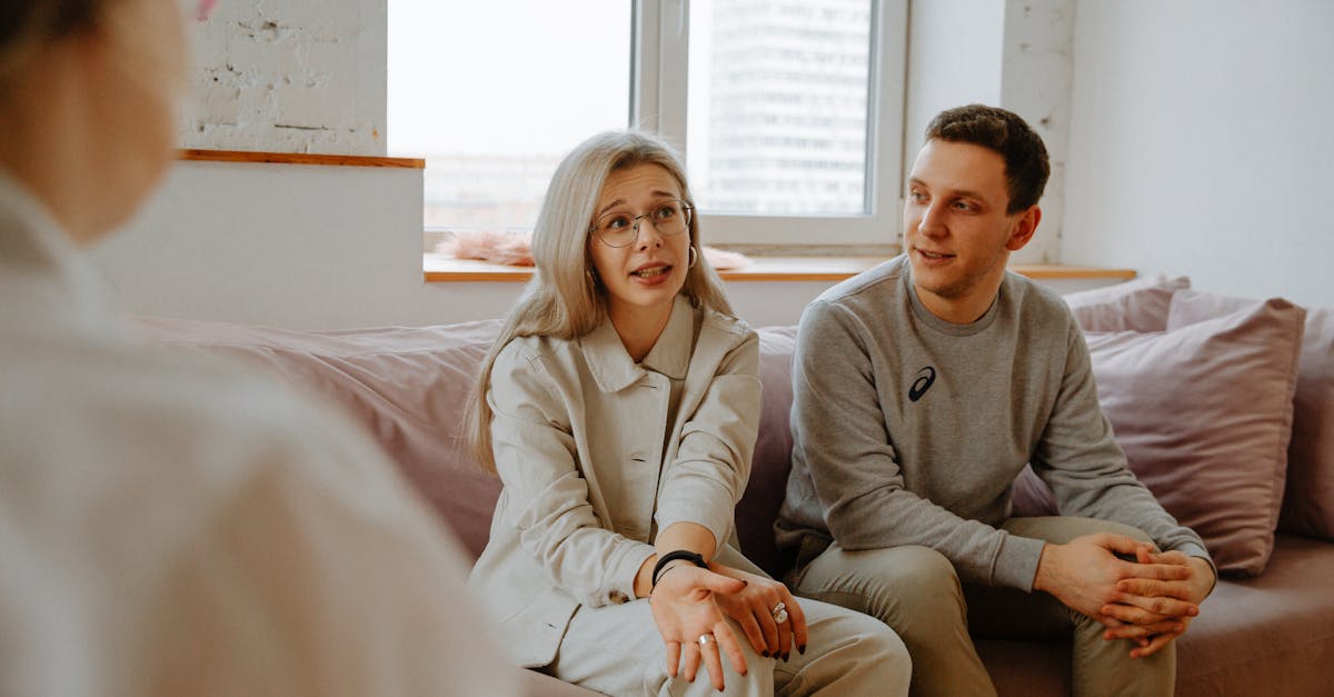 A couple and therapist engaged in a discussion during a therapy session indoors.