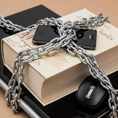 Hand holding black machined steel mechanical pencil with brass tip and top.