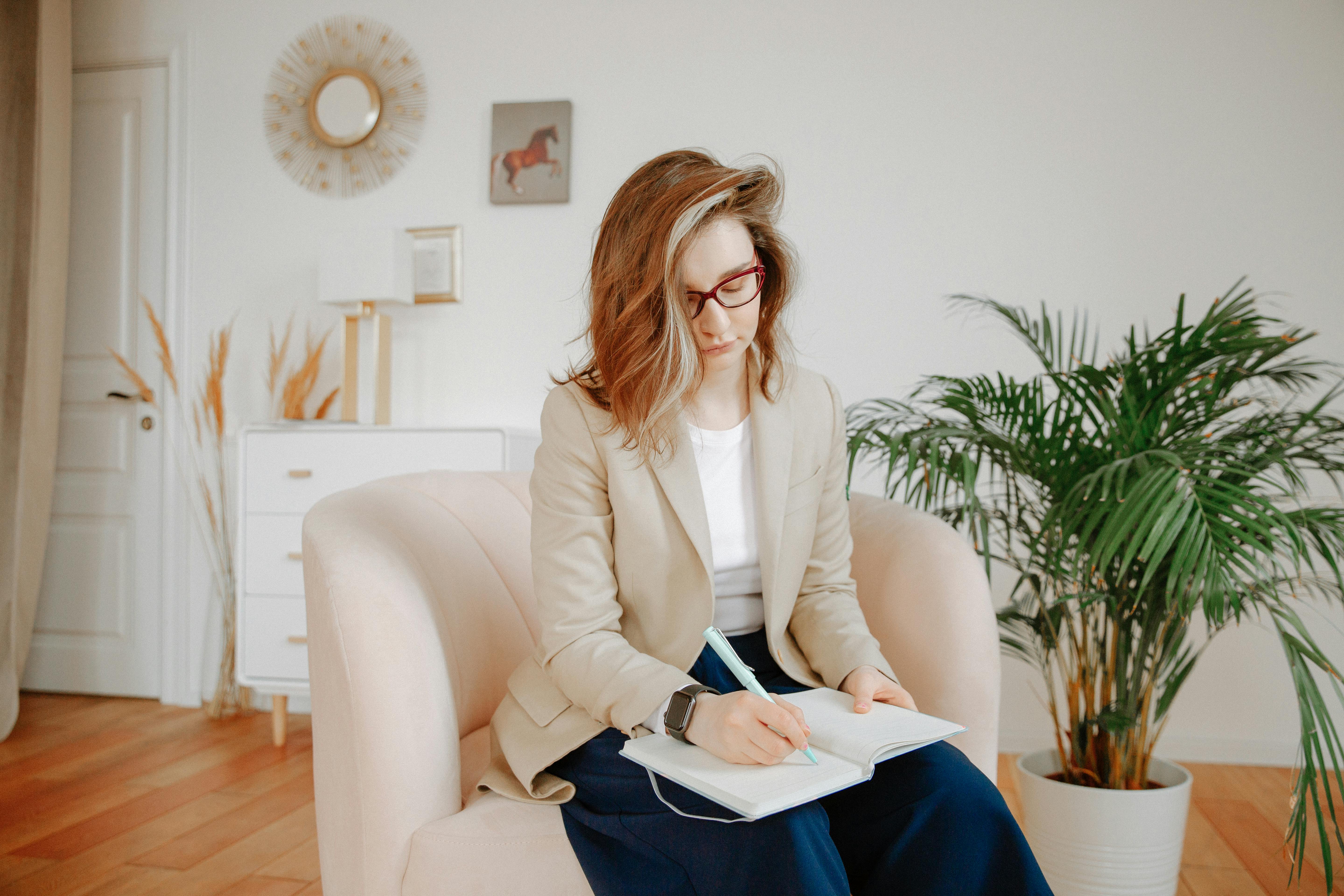 A female therapist taking notes during a session in a stylish office setting