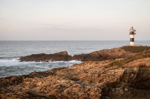 Free Scenic view of a coastal lighthouse on rocky cliffs in Ribadeo, Spain during the day. Stock Photo