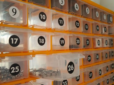 Side view of a hardware storage system with numbered bins containing nuts.