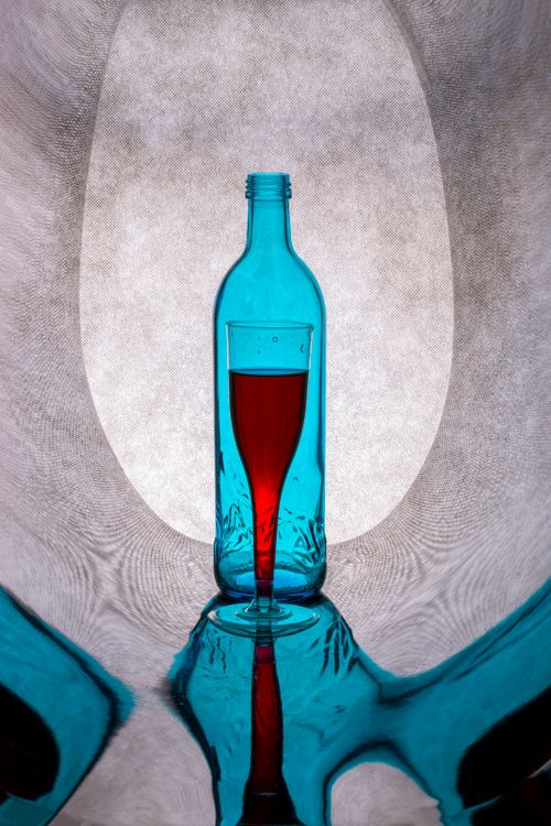 Free A striking image of a blue glass bottle filled with red liquid, artistically lit. Stock Photo