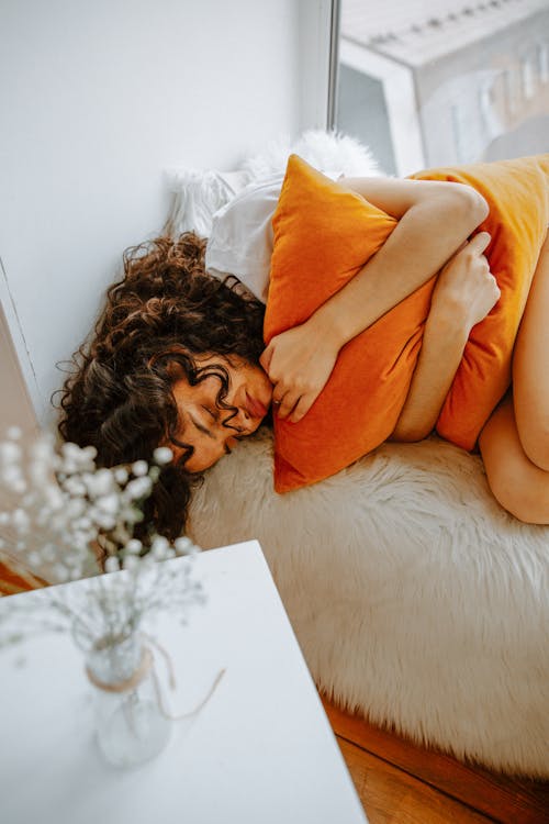 Free Woman Curled Up in Bed Stock Photo
