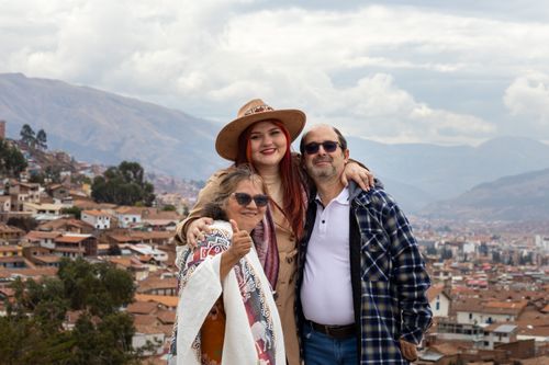 Free Happy family poses against the breathtaking backdrop of Cusco's cityscape and mountains. Stock Photo