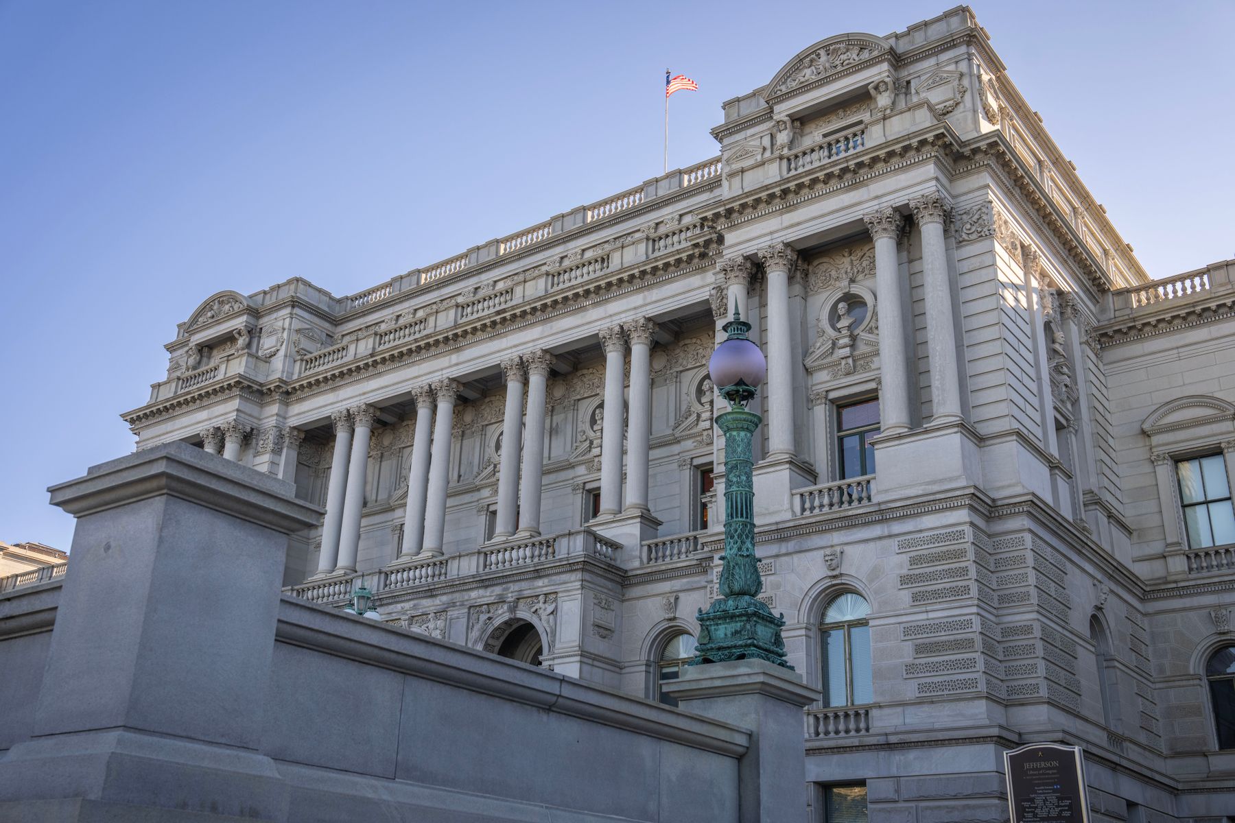 Historic Library of Congress building in Washington, D.C., with ornate stone architecture under a clear blue sky.