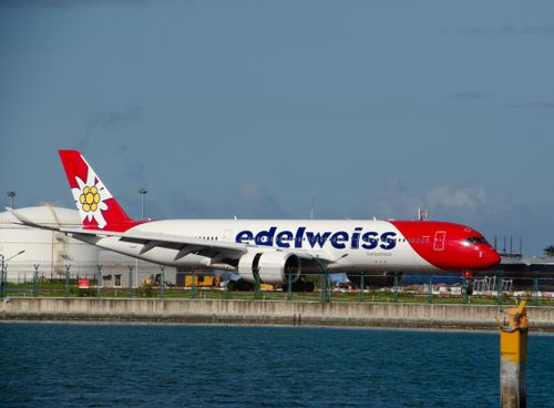Free Edelweiss aircraft on the tarmac at a Maldives airport, under a blue sky. Stock Photo