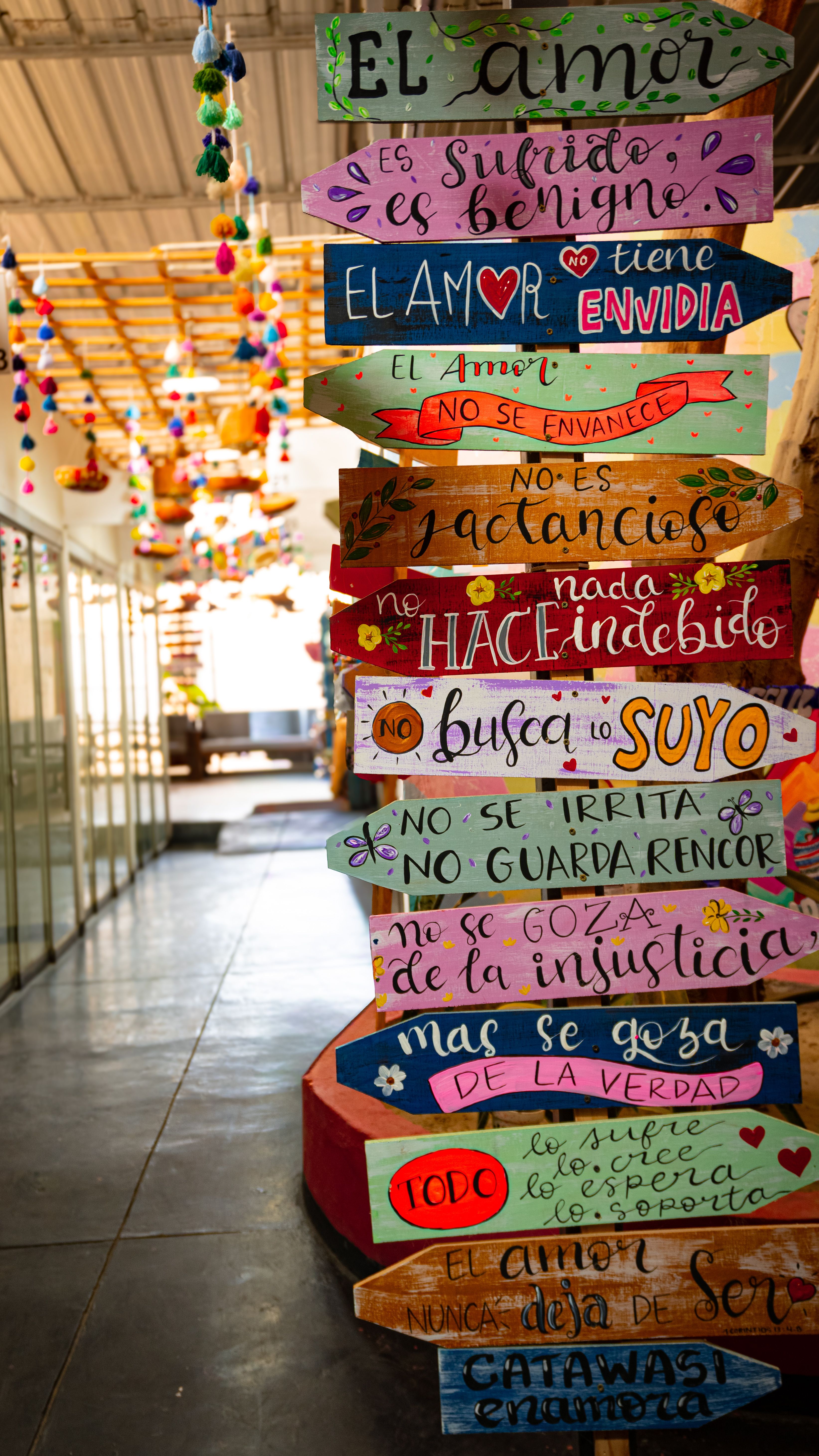 Vibrant handmade signs featuring positive messages in a lively indoor corridor.