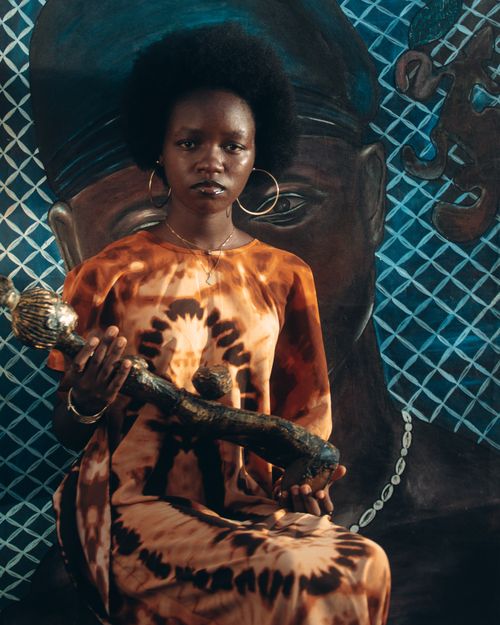 Free A striking portrait of a woman holding a sculptural artifact in front of artistic backdrop. Stock Photo