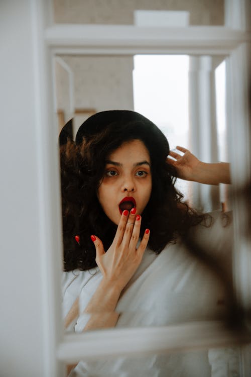 Free Surprised Woman Looking in Mirror Stock Photo