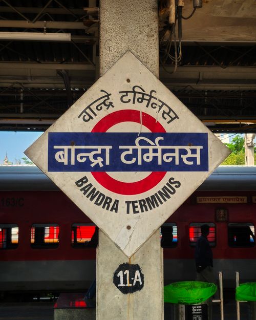 Free Iconic Bandra Terminus sign with train in background, Mumbai, India. Stock Photo