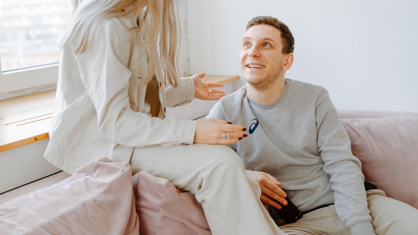 Two adults talking while sitting on a sofa