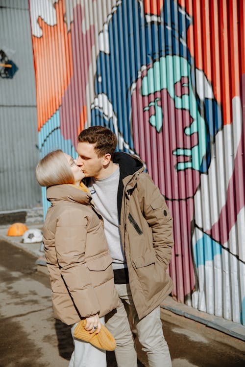 Free Man in Brown Coat Kissing Woman in Brown Coat Stock Photo