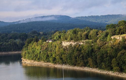 Free Peaceful landscape of the Ozarks with lush greenery by the water under a calm sky. Stock Photo