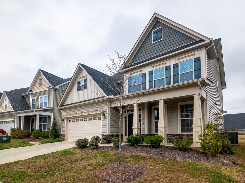 Row of modern suburban homes with garages and landscaped lawns