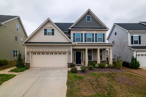 Free A modern two-story family home with a garage and landscaped yard in a suburban setting. Stock Photo