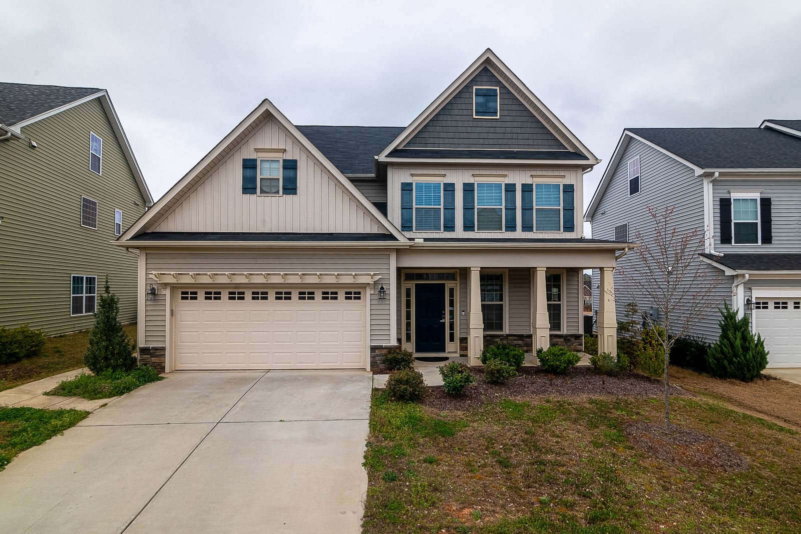 Larger two-story home with board-and-batten and shake siding, a covered front porch with columns, and an attached two-car garage on a landscaped lot, Olesen Estates, Naperville IL
