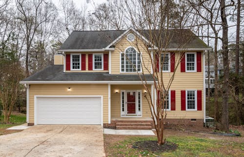 Cream and Red House Near Bare Trees