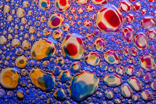 Free A vibrant and colorful macro shot of soap bubbles reflecting light in an abstract pattern. Stock Photo