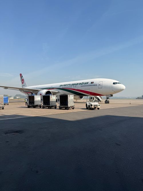 Free Biman Bangladesh Airlines plane on tarmac at Dhaka Airport under clear skies. Stock Photo