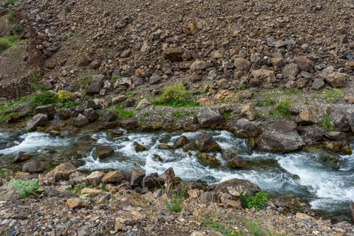 Free Scenic view of Mogiyandarya River flowing through rocky terrain in the picturesque Fann Mountains. Stock Photo