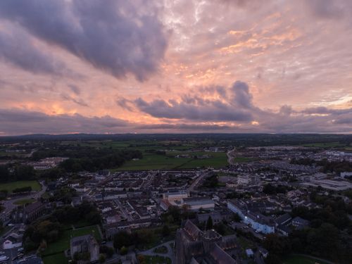 Free A stunning aerial view of a town during sunset showcasing dramatic skies and sprawling landscapes. Stock Photo