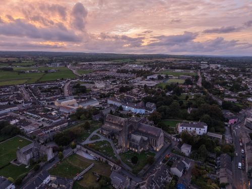 Free Breathtaking aerial sunset view over a sprawling urban landscape and historical cathedral. Stock Photo