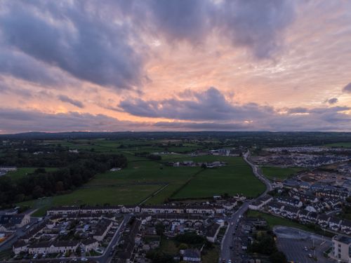 Free Aerial view of a countryside landscape at sunset with vibrant skies and distant fields. Stock Photo