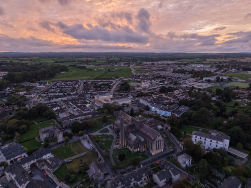 Free Breathtaking aerial shot of a European town with a prominent cathedral at sunset. Stock Photo