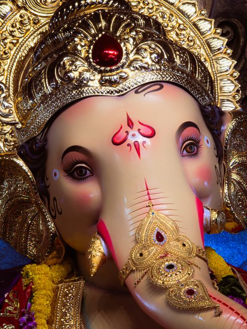 Free Close-up of a beautifully adorned Ganesh idol showcasing intricate gold details and vivid colors. Stock Photo