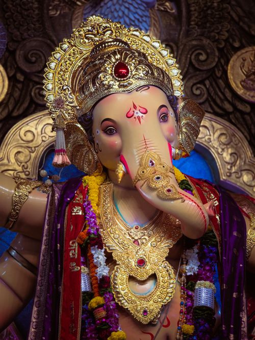 Free Colorful representation of Lord Ganesha, adorned with intricate jewelry and flowers, showcasing Hindu culture and art. Stock Photo
