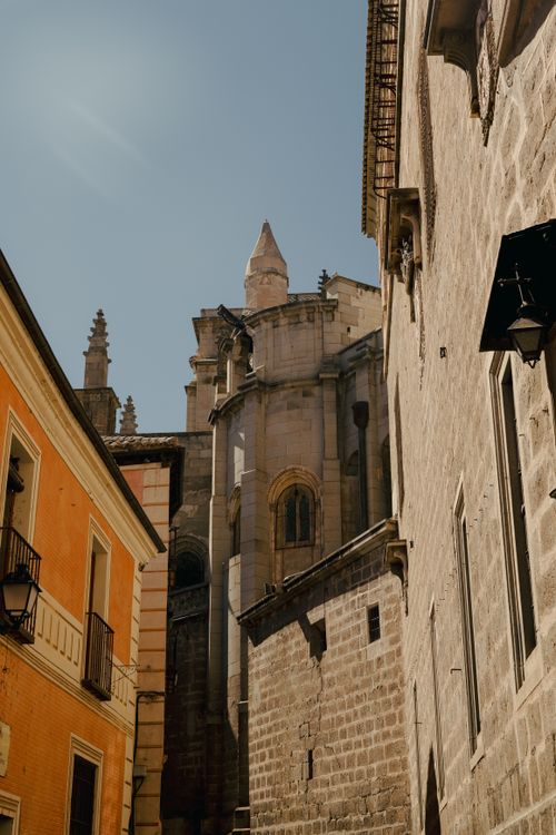 Free Sunlit alley with historic architecture under a clear blue sky in a European city. Stock Photo