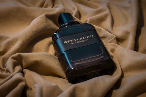 Free Stylish Gentleman by Givenchy perfume bottle on luxurious beige fabric background. Stock Photo
