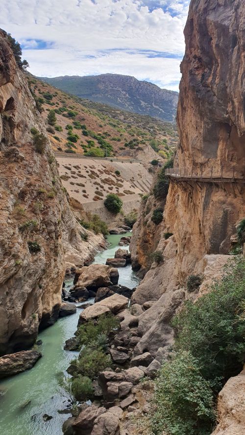 Free Breathtaking view of a rocky gorge with a river flowing through it and scenic mountains in the background. Stock Photo