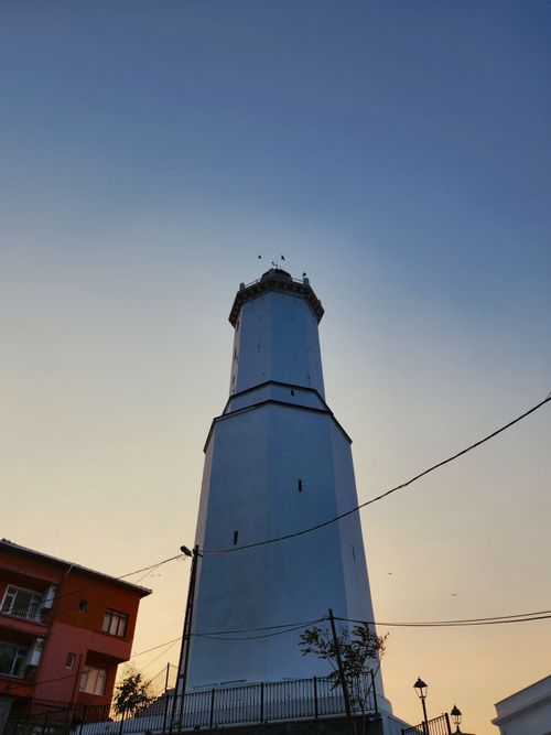Free A towering white lighthouse against a pastel sky captured at sunset. Stock Photo