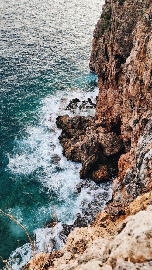 Free Stunning cliffside view in Antalya, Türkiye with turquoise ocean waves crashing ashore. Stock Photo
