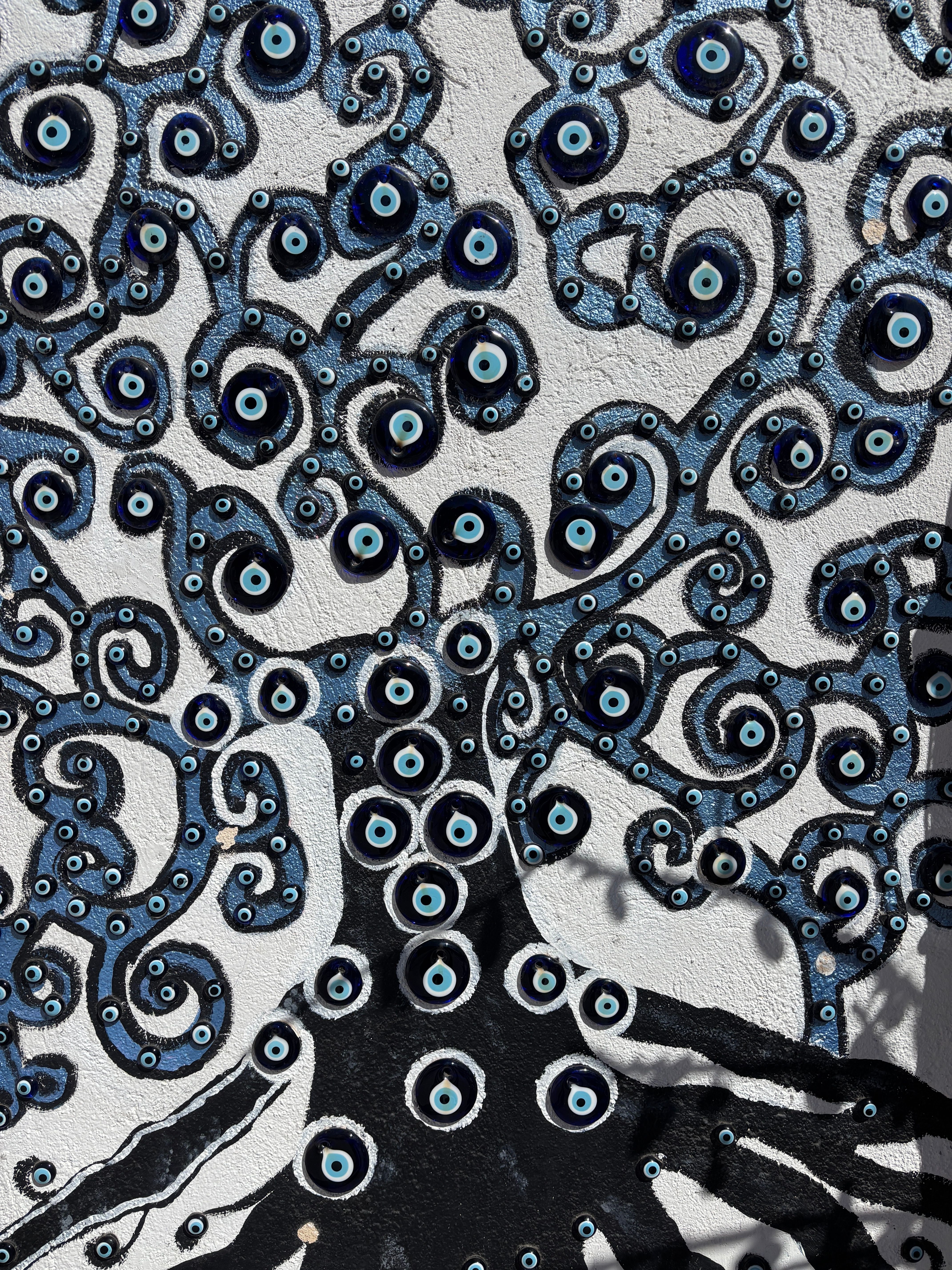 Artistic evil eye mosaic on a wall with swirling patterns in Cappadocia, Turkey.