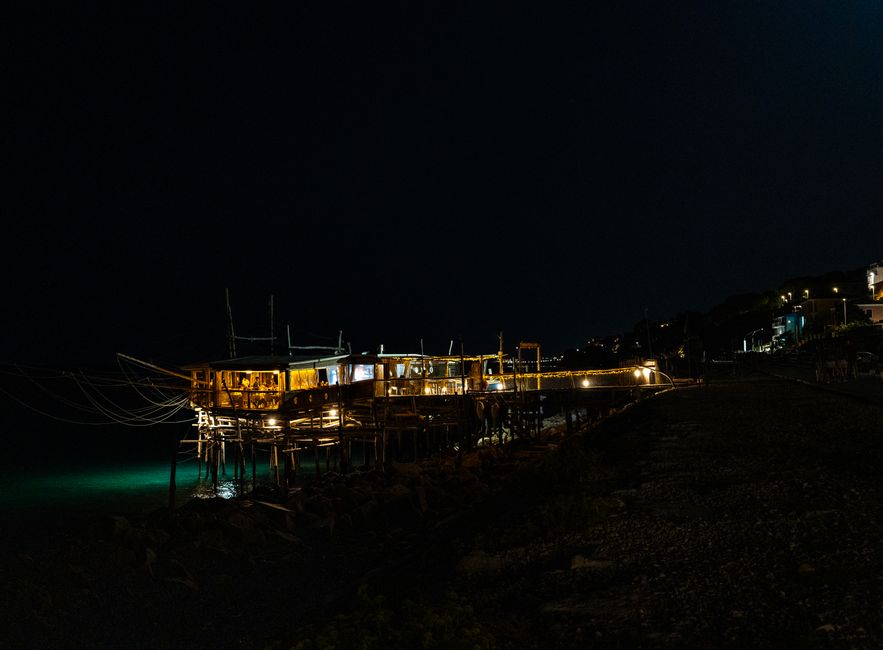 夜の堤防でアジングをするアングラーの遠景