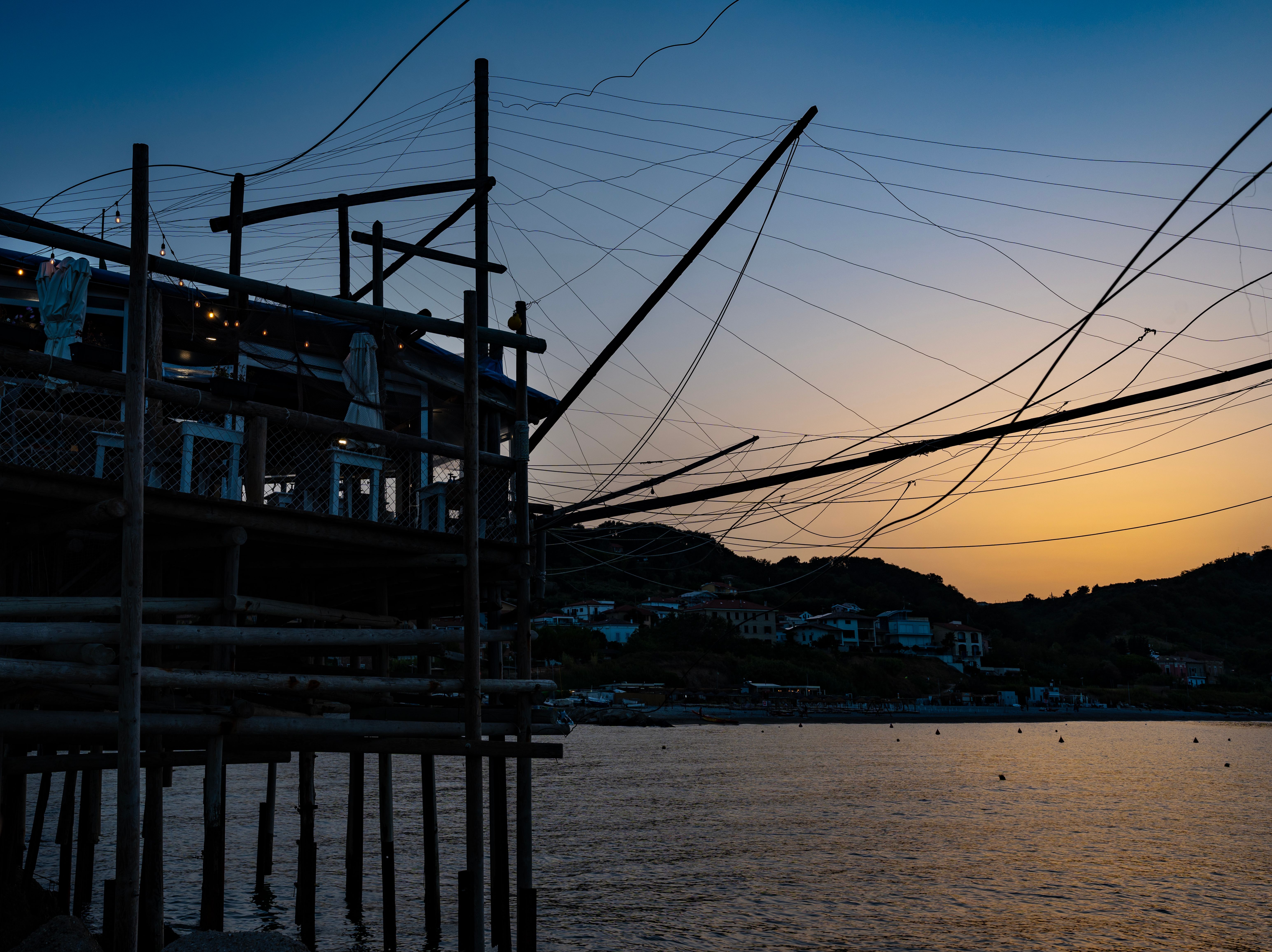 Explore the enchanting trabocchi of Marina di San Vito, Italy during a serene sunset.