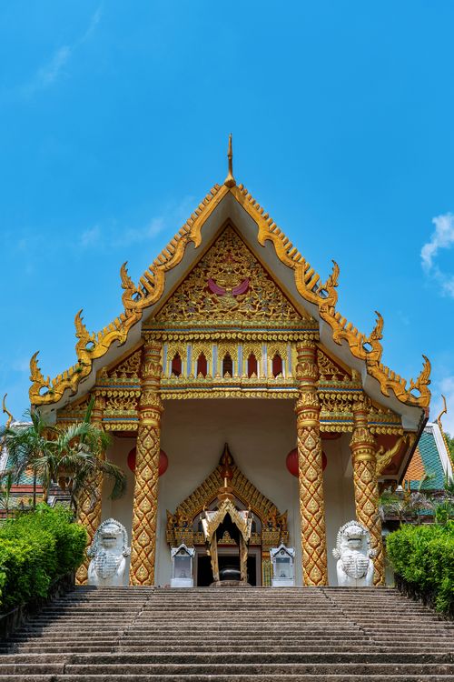 Free A beautiful Thai temple featuring intricate architectural details under a clear blue sky. Stock Photo