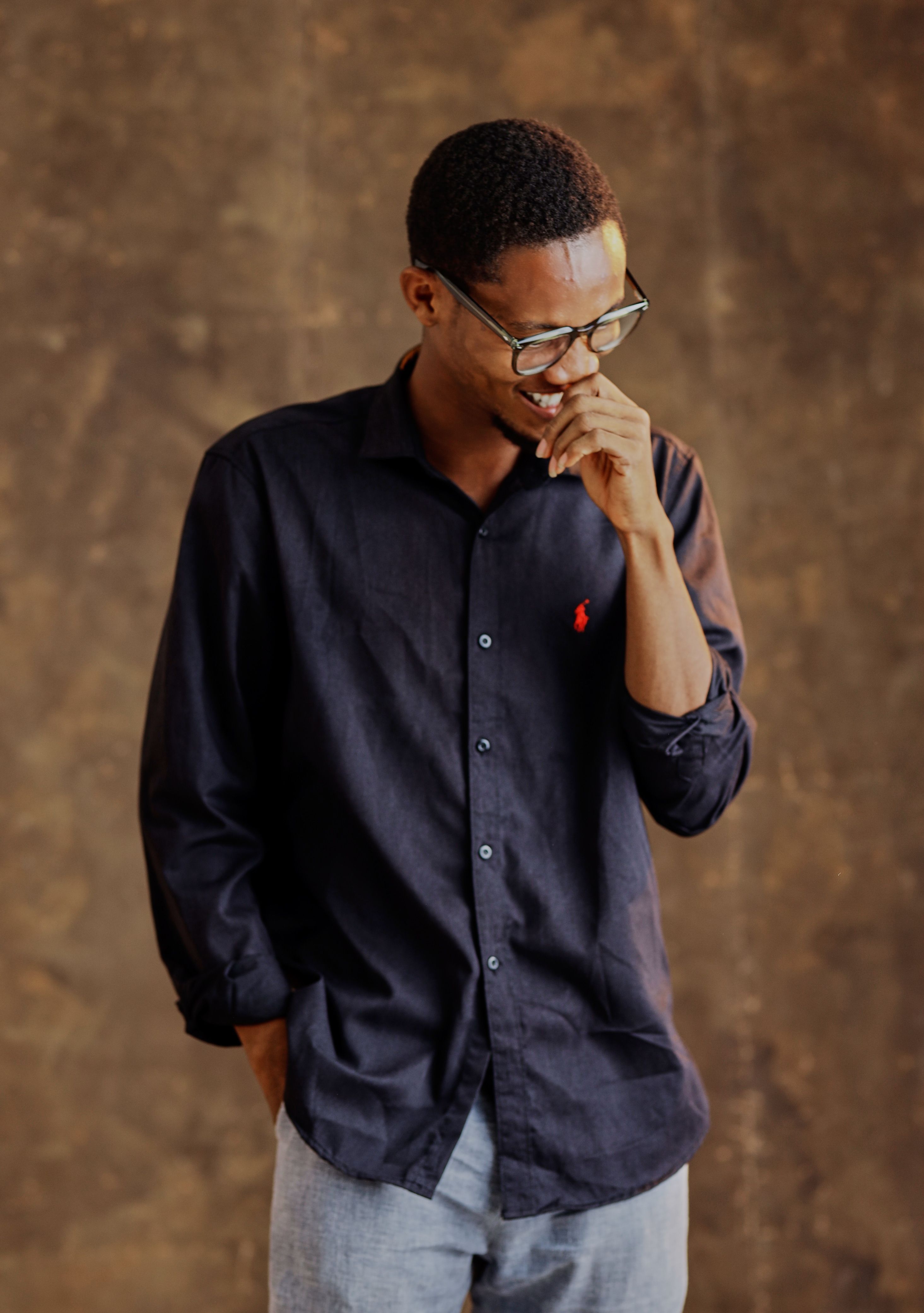 Portrait of a man in glasses with a stylish pose and neutral background.