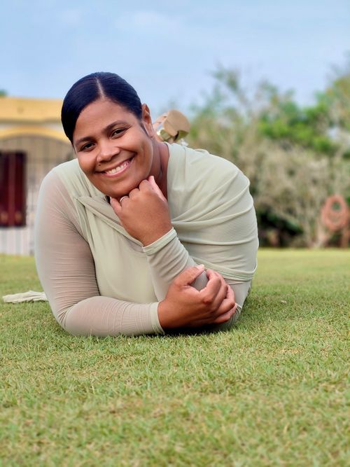 Free A cheerful woman lying on the lawn, enjoying a bright day outdoors. Stock Photo