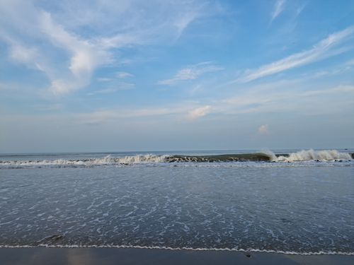 Free A serene view of ocean waves gently crashing under a vast blue sky. Stock Photo