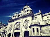 在晴朗的蓝天下，一座令人惊叹的白色锡克教寺庙展现出复杂的细节