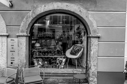 Free A stylish Swiss boutique storefront displaying modern decor through an arched window, captured in monochrome. Stock Photo