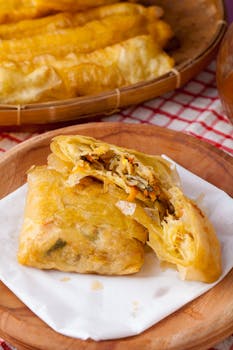 Golden fried vegetable spring rolls served on a wooden plate, perfect for appetizers.