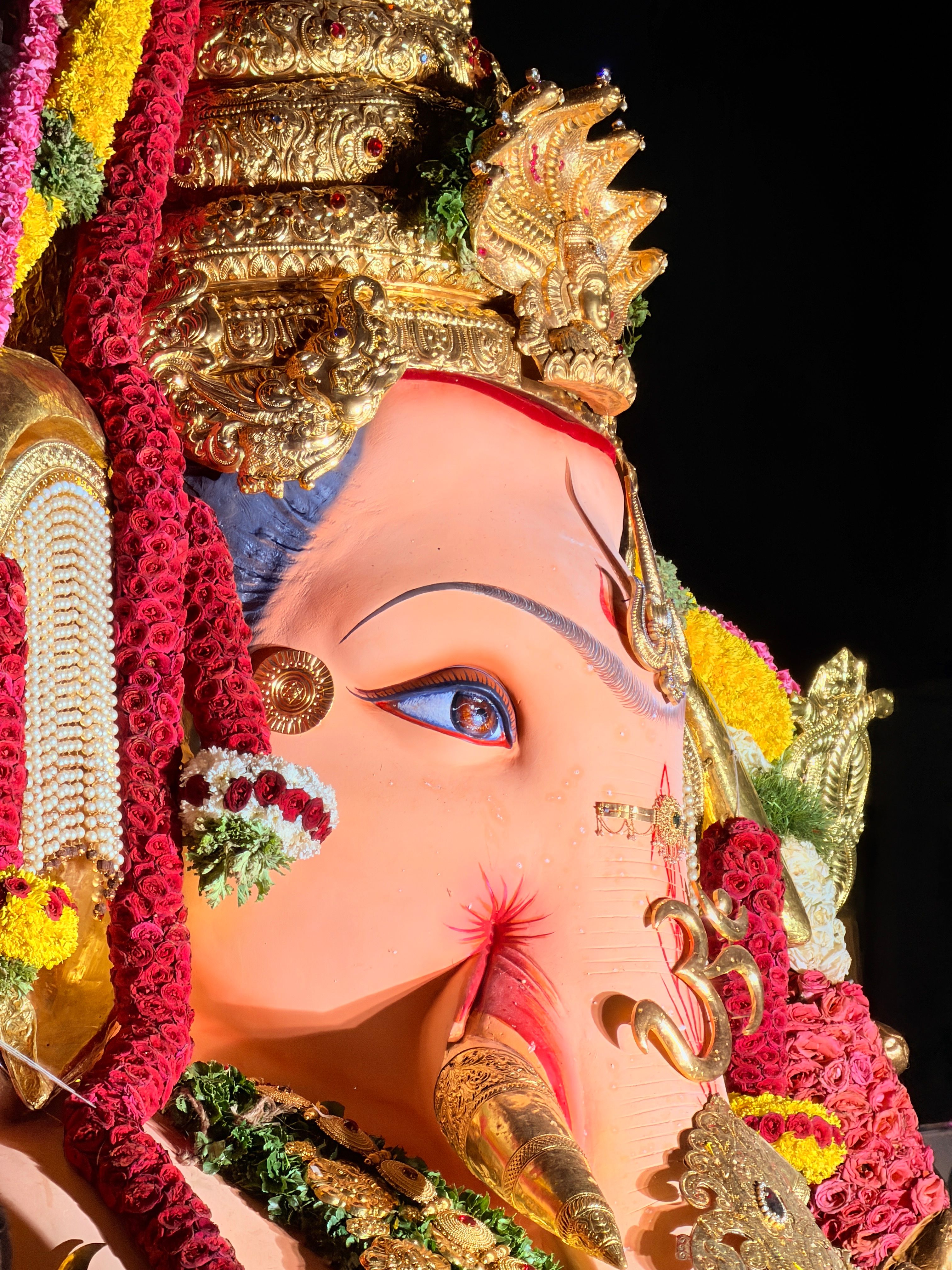 Close-up of a colorful and ornate Ganesh idol decorated for Indian festivals, showcasing intricate details.